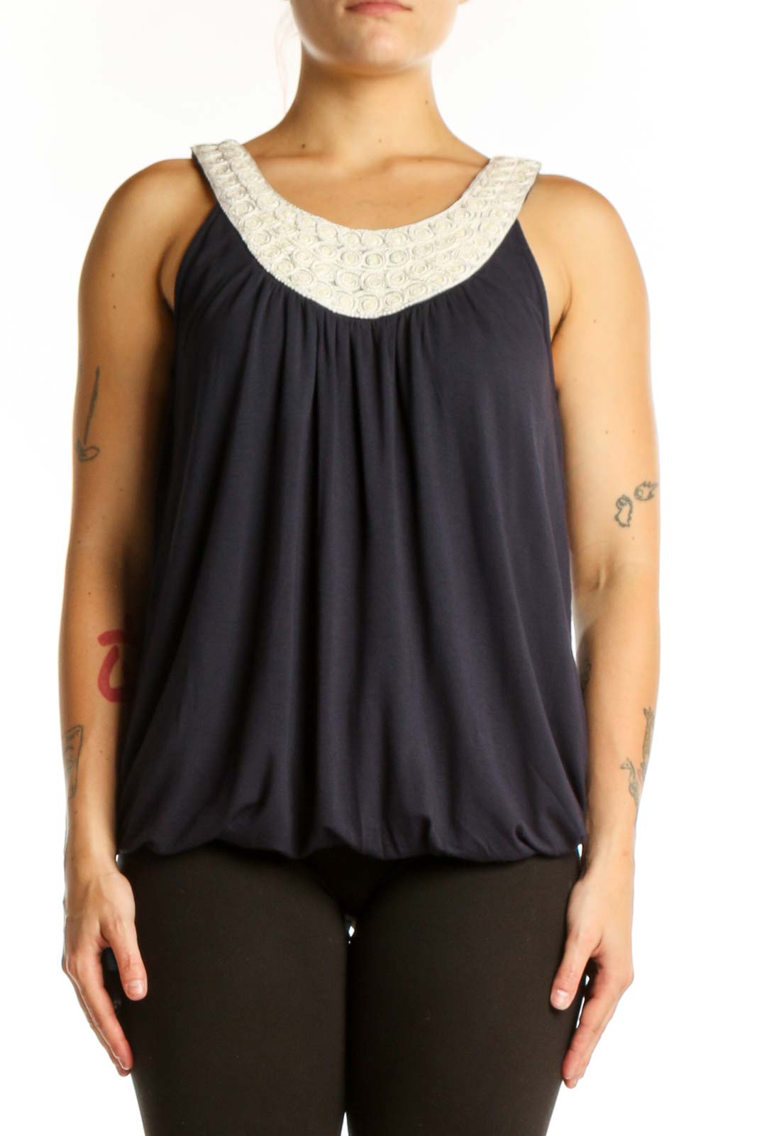 Navy sleeveless tank top with cream embellished beaded neckline and gathered front, worn with black pants