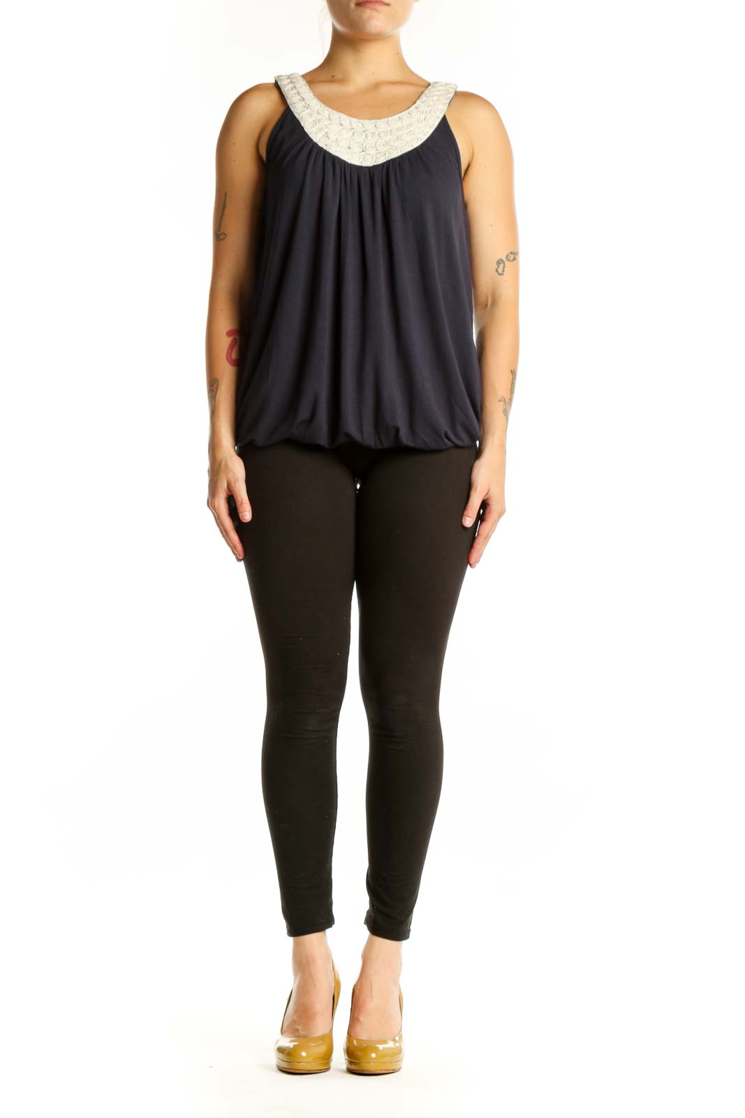 Navy sleeveless tank top with cream embellished beaded neckline and gathered front, worn with black pants