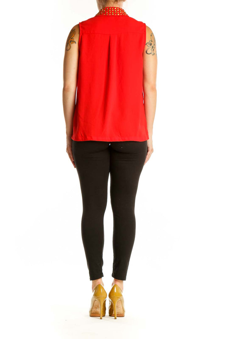 Red sleeveless button-up top with gold studded collar, back view on model