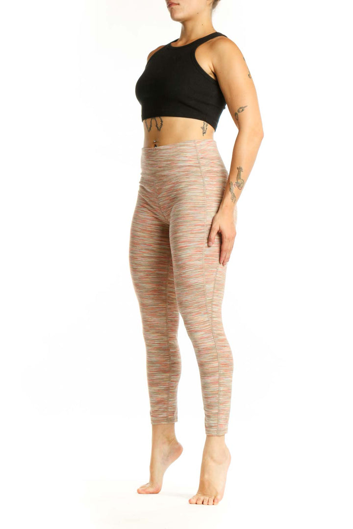 Front view of multicolor striped athletic leggings with horizontal coral, cream, and pastel stripes, high-waisted design, and cropped ankle length