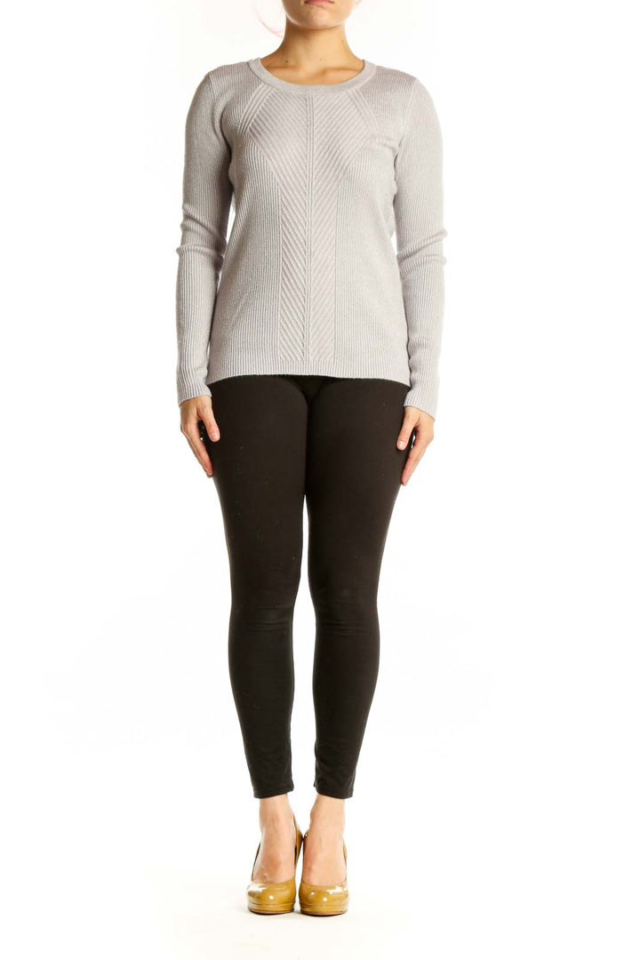 Cream ribbed knit sweater with metallic threading, crew neckline, and long sleeves on model wearing black pants