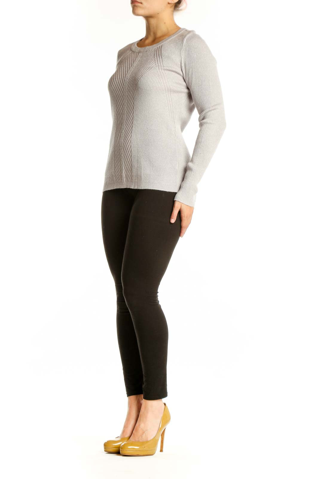 Cream ribbed knit sweater with metallic threading, crew neckline, and long sleeves on model wearing black pants