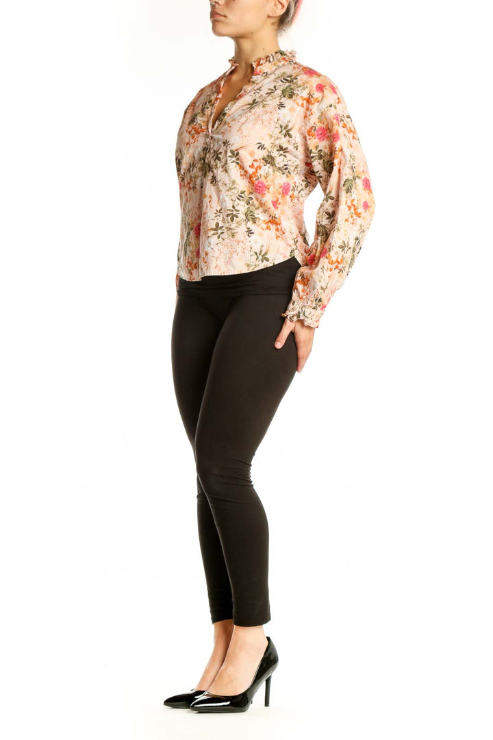 Cream floral Pima cotton button-up top by Amo with coral, pink, and sage green flowers, front view on model