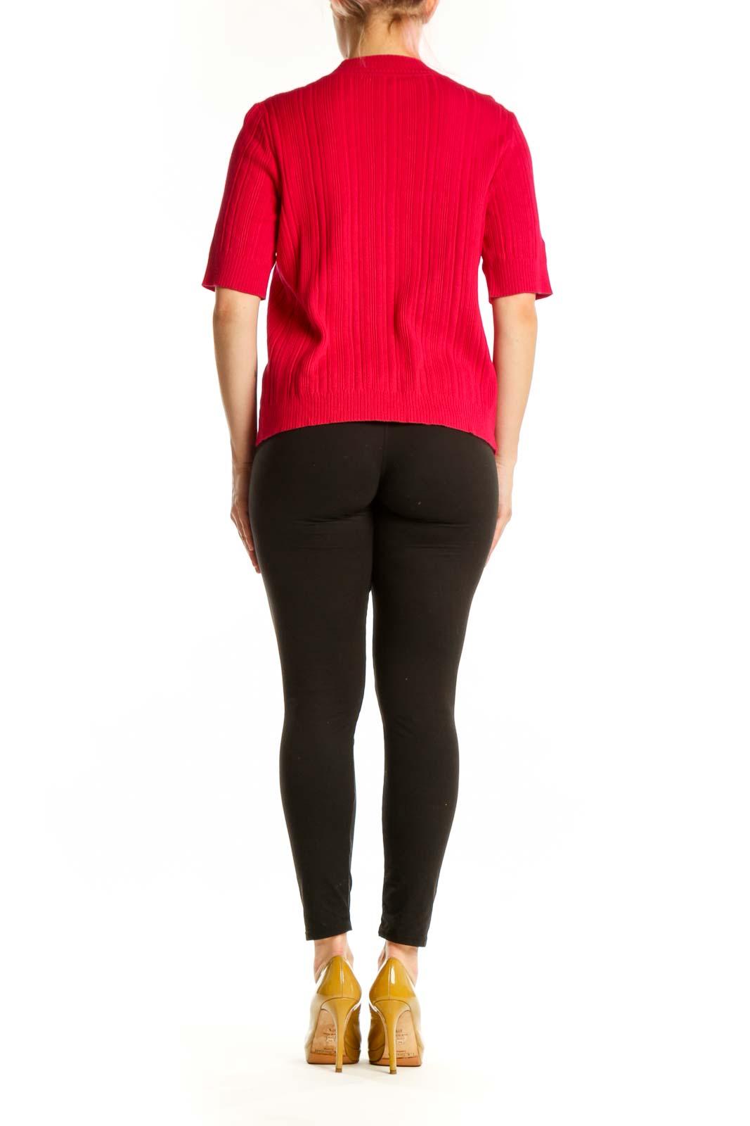 Back view of red ribbed knit cardigan showing relaxed fit and drape, paired with black leggings and gold heels