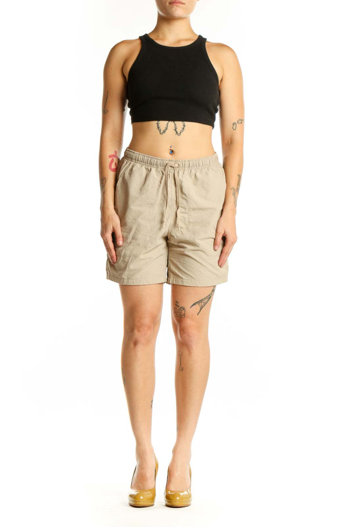 Beige DSG athletic shorts with elastic waistband and drawstring, front view on model