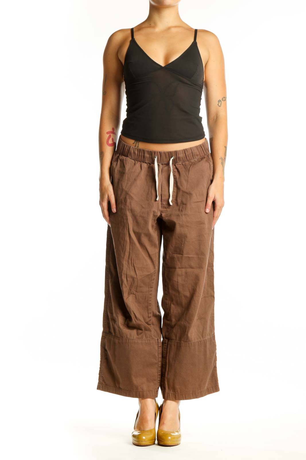 Brown organic cotton drawstring pants with relaxed fit and front pockets, shown on model from front view