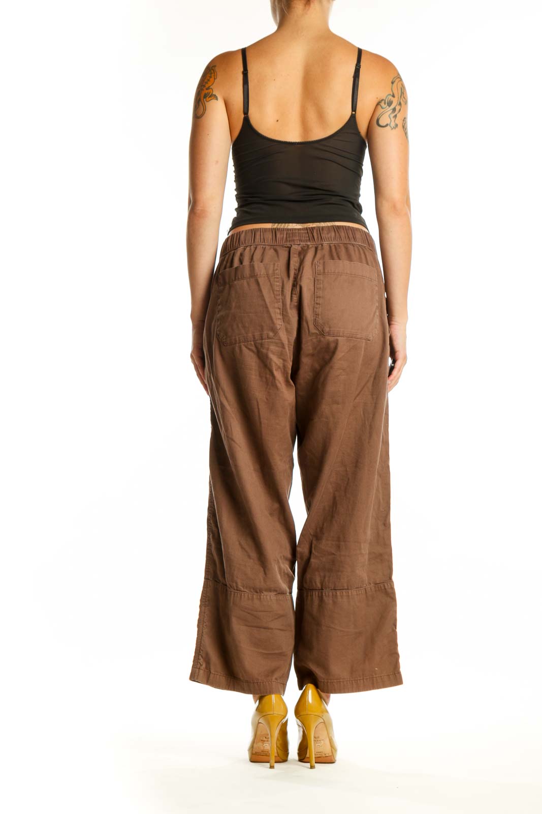 Back view of brown organic cotton drawstring pants showing relaxed silhouette and functional back pockets