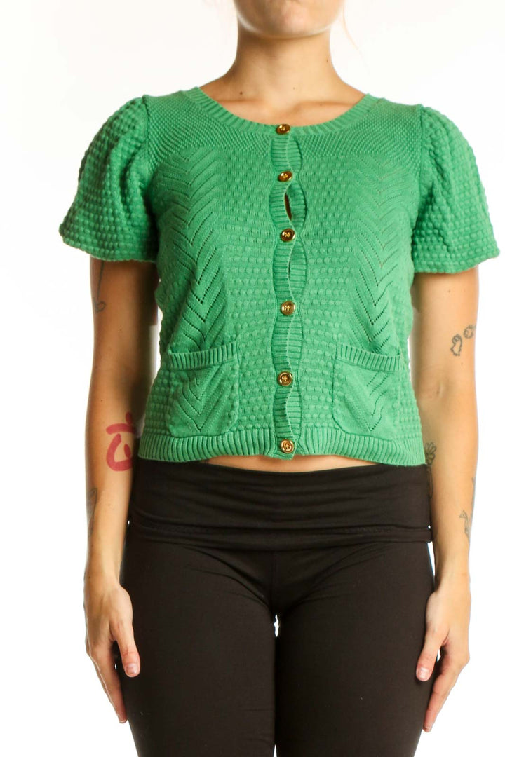 Green knit button-up cardigan with textured cable pattern, puffed sleeves, and gold buttons on model
