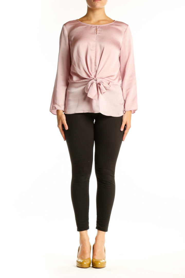 Pink tie-front long sleeve blouse with crew neckline, front view on model