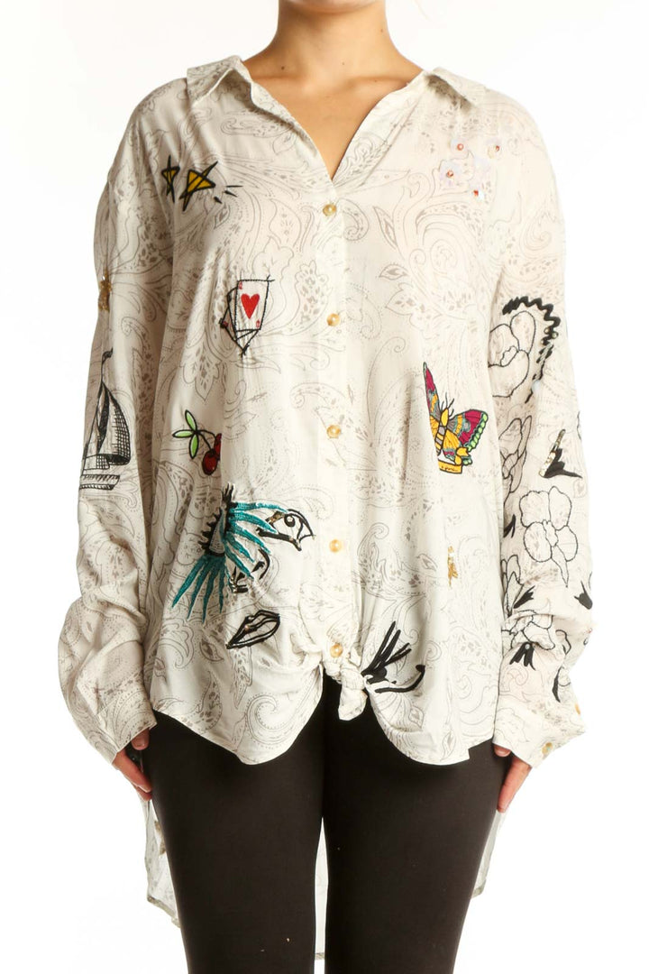 Cream Pilcro rayon shirt with whimsical embroidered birds, butterflies, hearts, and line drawings on front, worn with black leggings