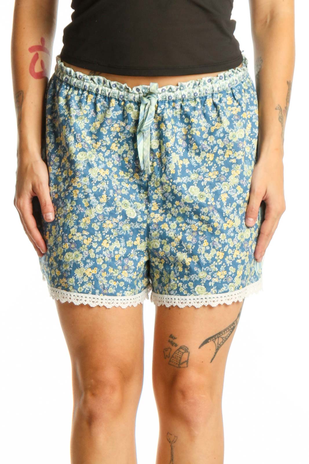 Blue floral shorts with yellow flowers and cream lace trim, featuring drawstring waistband and relaxed fit