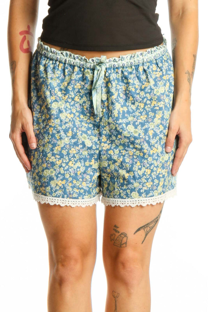 Blue floral shorts with yellow flowers and cream lace trim, featuring drawstring waistband and relaxed fit