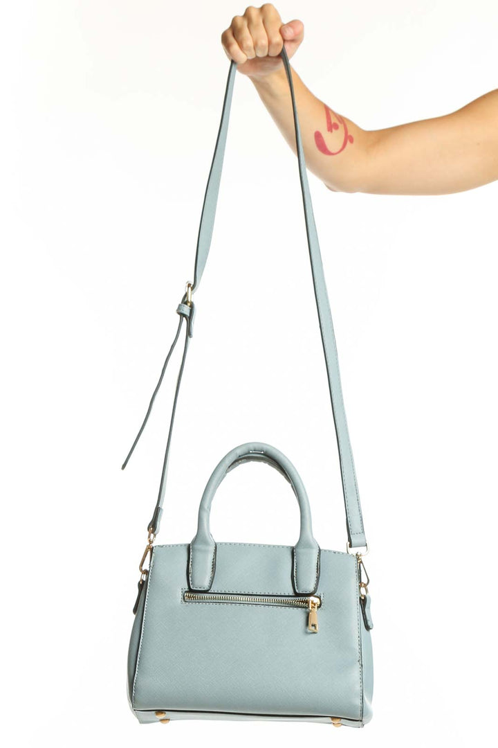 Light blue SilkRoll shoulder bag with dual handles and adjustable crossbody strap, displayed with gold-tone hardware and front zip pocket