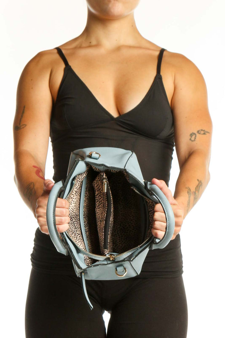 Back view of light blue SilkRoll shoulder bag worn as crossbody style, showing structured silhouette and adjustable strap design