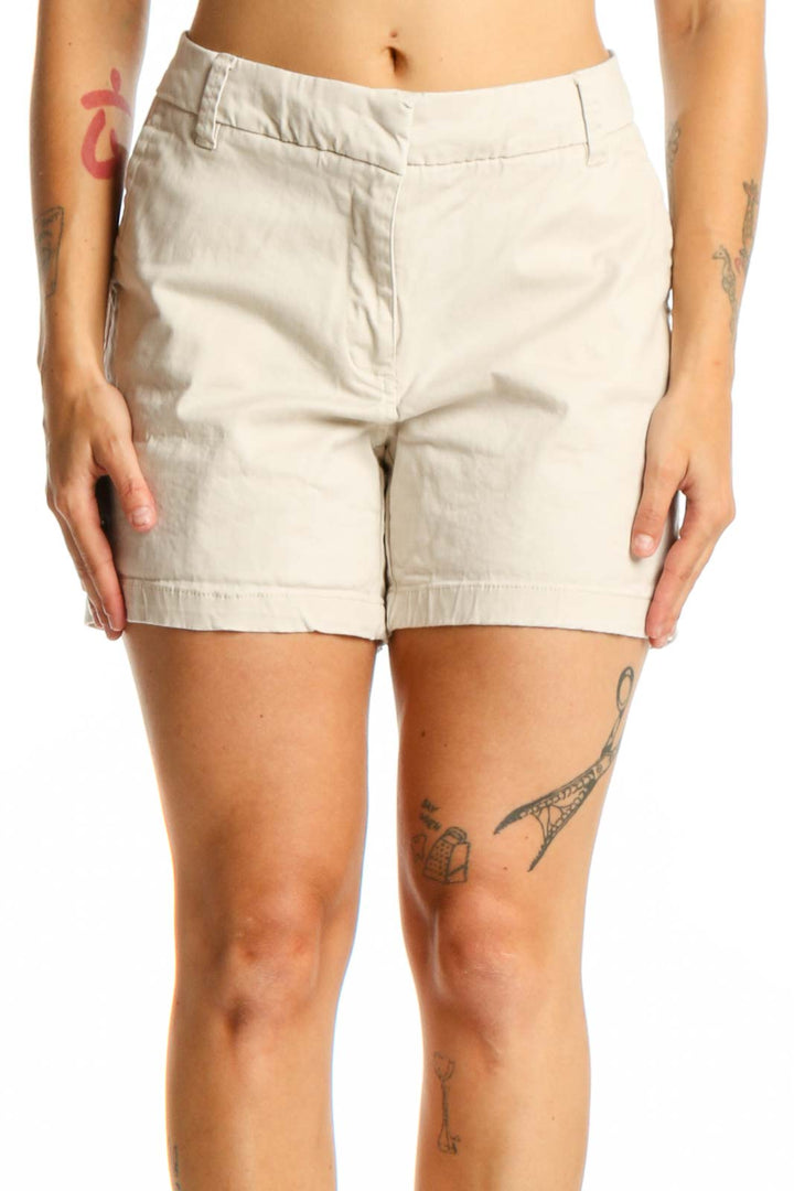 Front view of cream cotton-spandex blend shorts with zip fly closure and five-pocket design