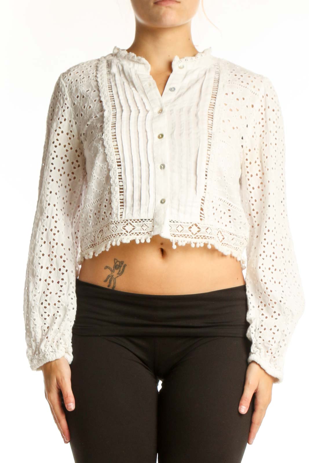 Cream eyelet cropped button-up top with pleated front and lace detailing, worn with black pants