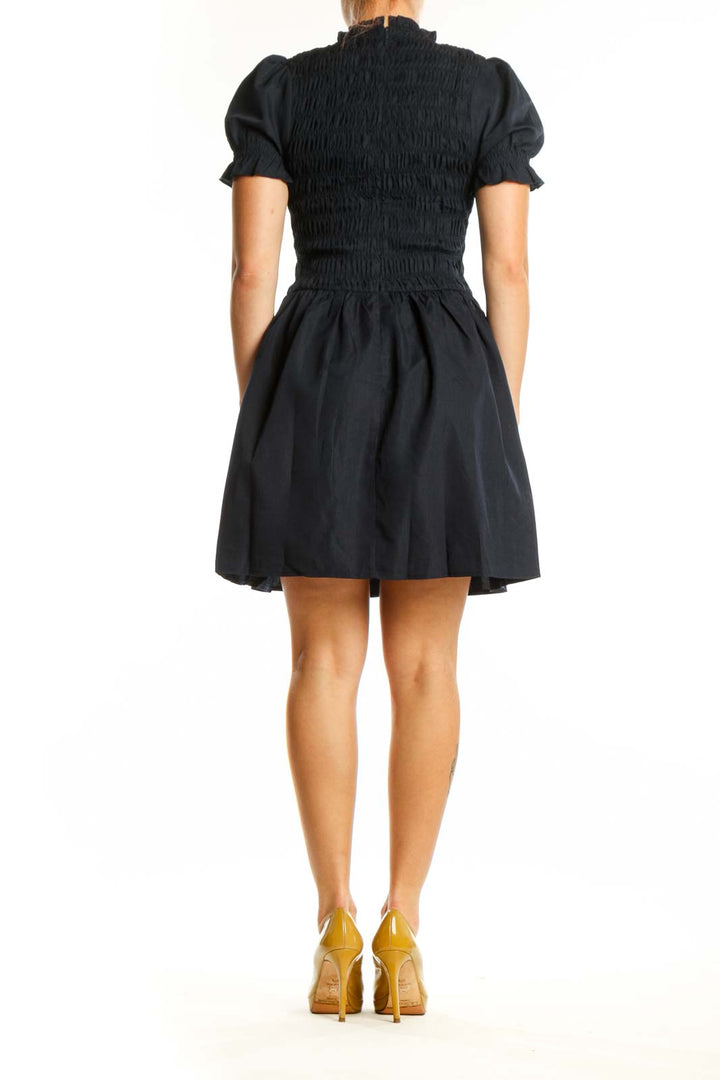 Black puff sleeve smocked fit and flare dress back view, displaying smocked detailing and A-line silhouette