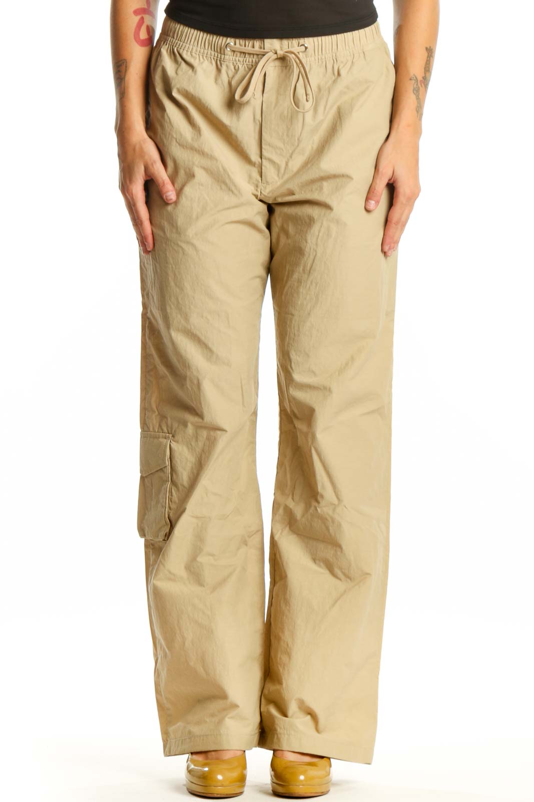 Beige cargo pants with drawstring waist and thigh pockets, front view on model