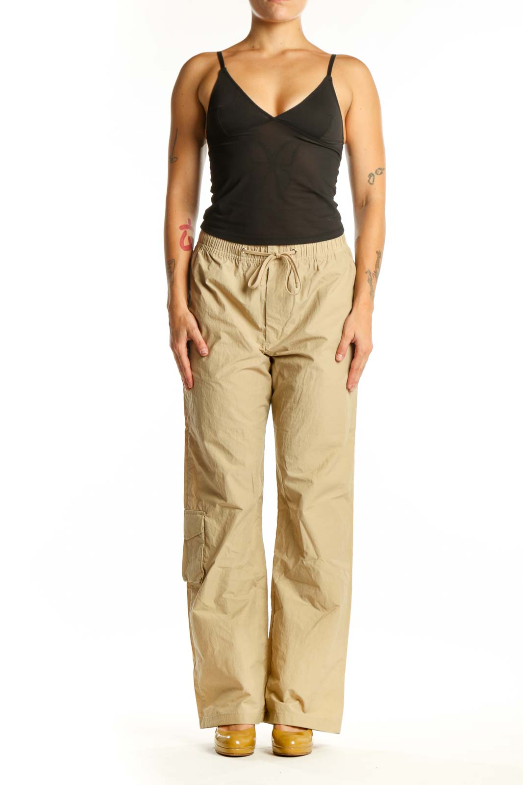 Beige cargo pants with drawstring waist and thigh pockets, front view on model