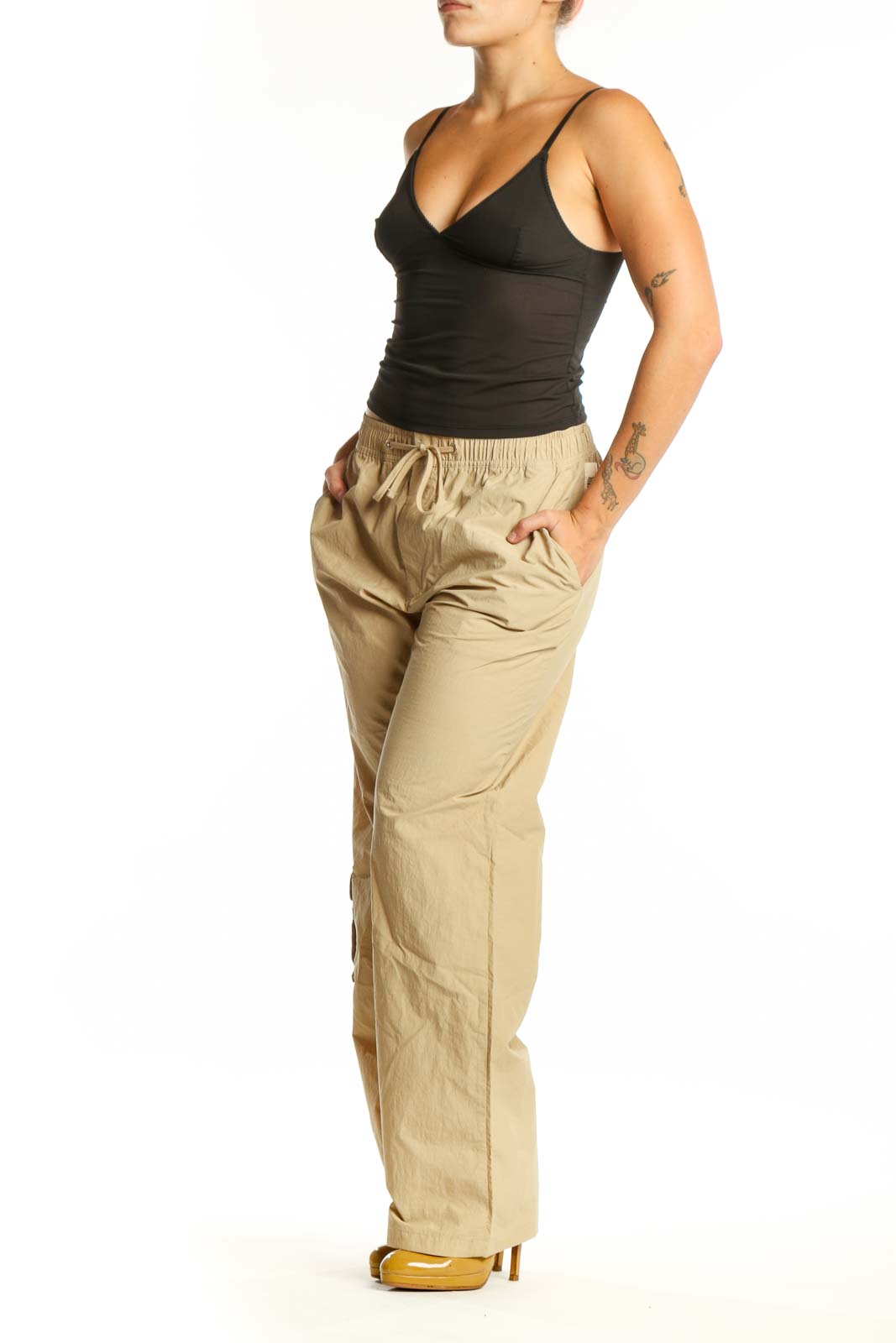 Beige cargo pants with drawstring waist and thigh pockets, front view on model