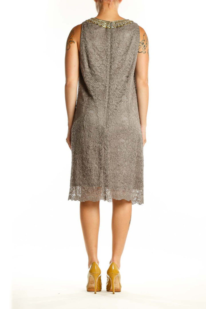 Back view of gray lace cocktail dress showing sleeveless silhouette and textured lace pattern