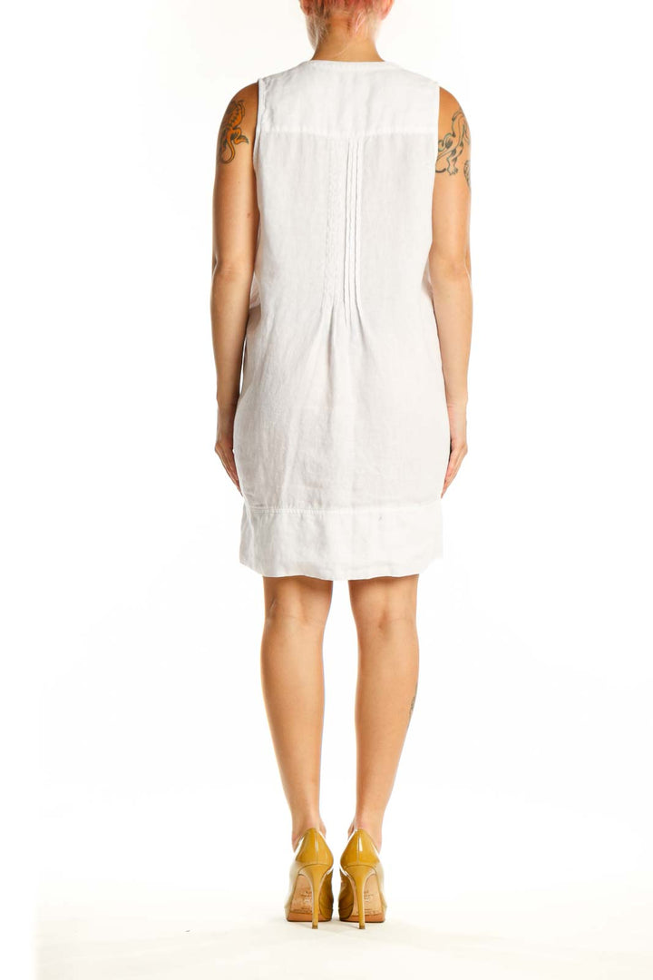 White linen sleeveless button-front dress with side pockets, back view