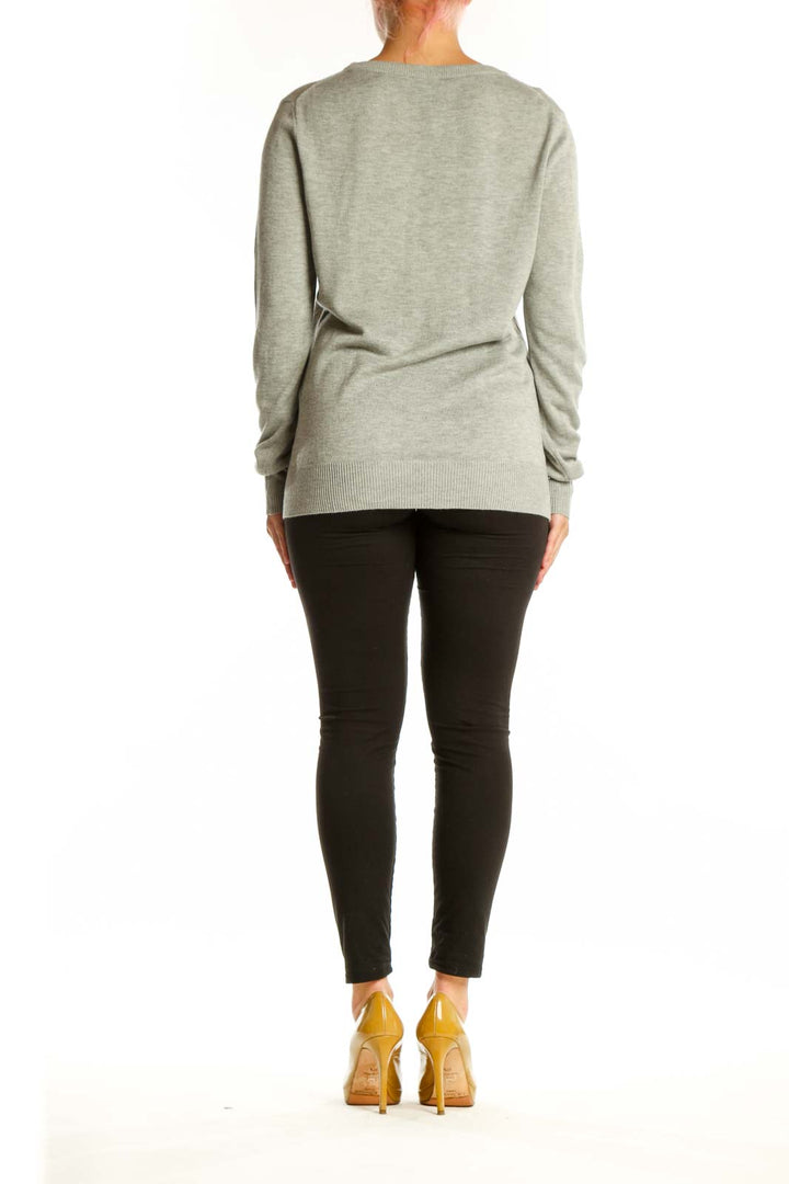 Back view of beige knit pullover sweater showing clean silhouette and relaxed fit