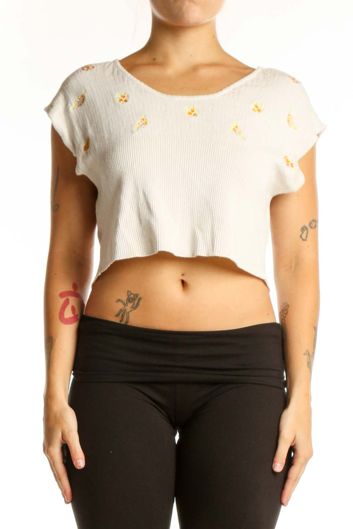 Cream ribbed crop top with gold floral embroidery, short cap sleeves, front view