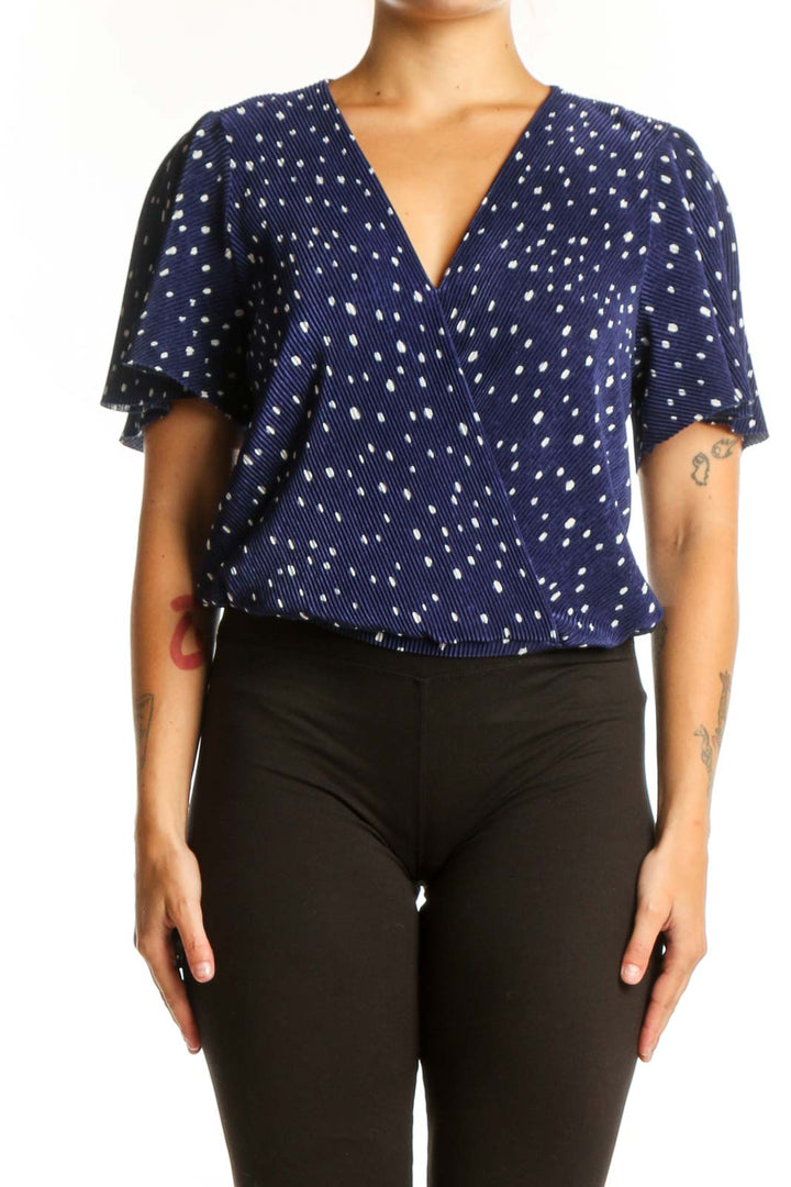 Navy polka dot wrap top with flutter sleeves, front view on model