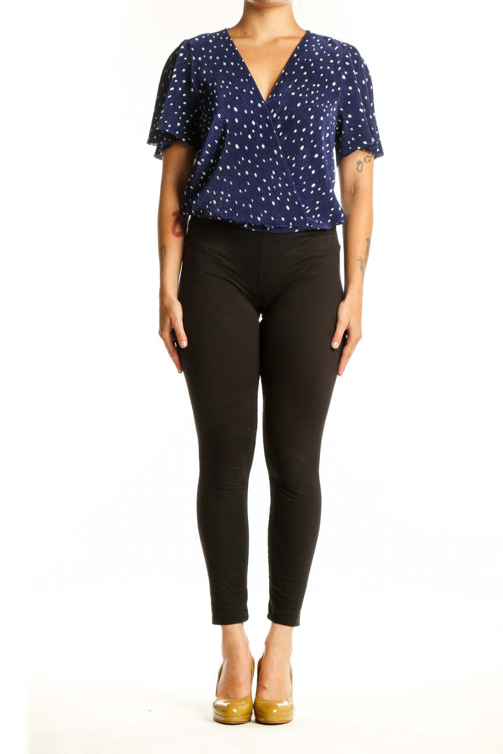 Navy polka dot wrap top with flutter sleeves, front view on model