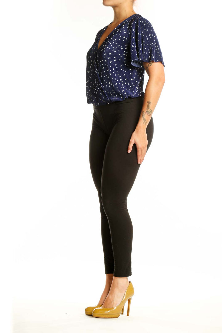 Navy polka dot wrap top with flutter sleeves, front view on model