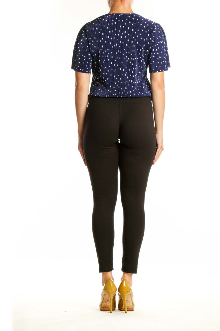 Navy polka dot wrap top with flutter sleeves, back view on model