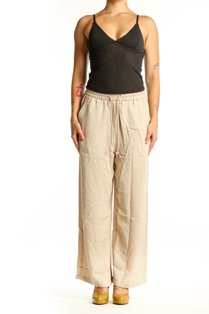 Cream wide leg drawstring pants with relaxed fit and side pockets, front view