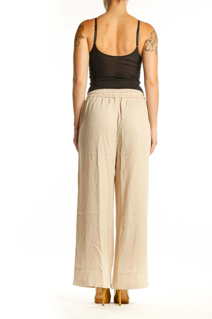 Cream wide leg drawstring pants with relaxed fit and side pockets, back view