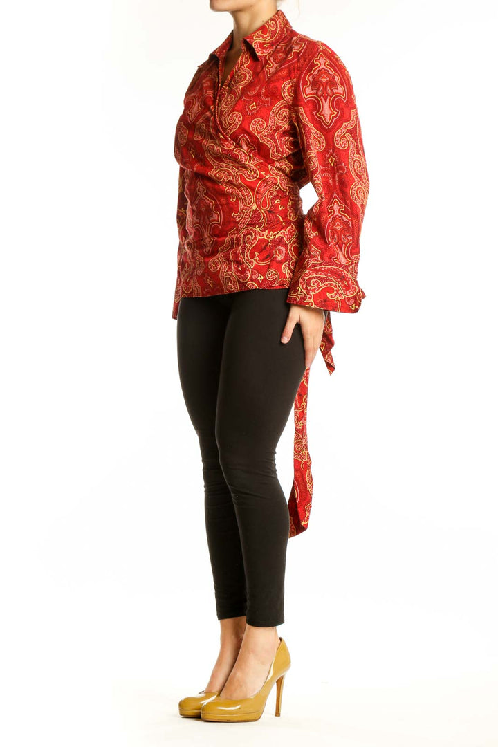 Red and gold paisley print button-up blouse with long sleeves and collar, front view