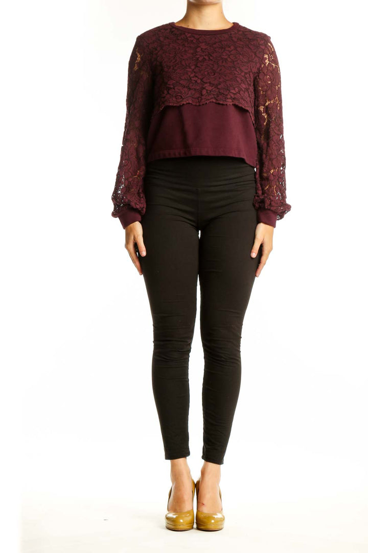Burgundy lace cropped knit top with long voluminous sleeves and solid panel, styled with black pants