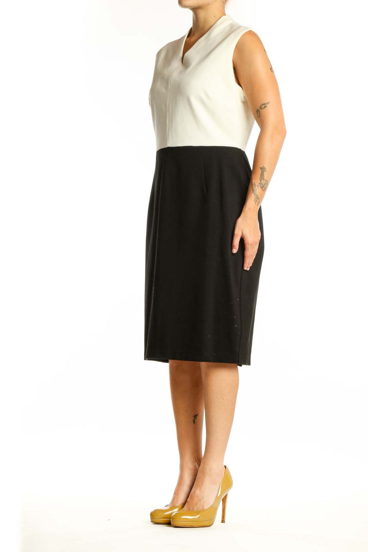 Front view of cream and black colorblock sleeveless dress with V-neckline and midi length