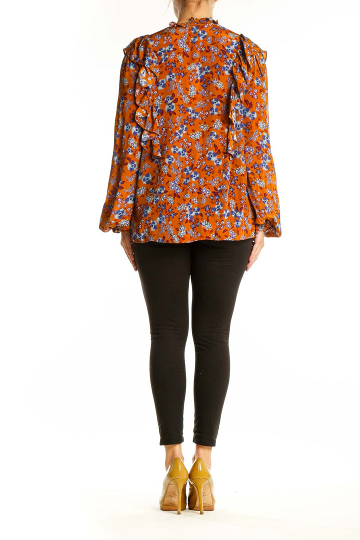 Back view of orange floral ruched viscose blouse showing gathered detailing and bell sleeve design