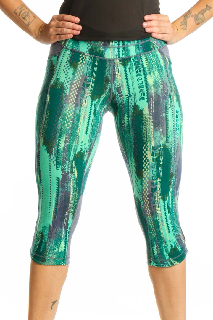 Front view of green geometric print Athleta capri leggings with high-waisted design and four-way stretch fabric