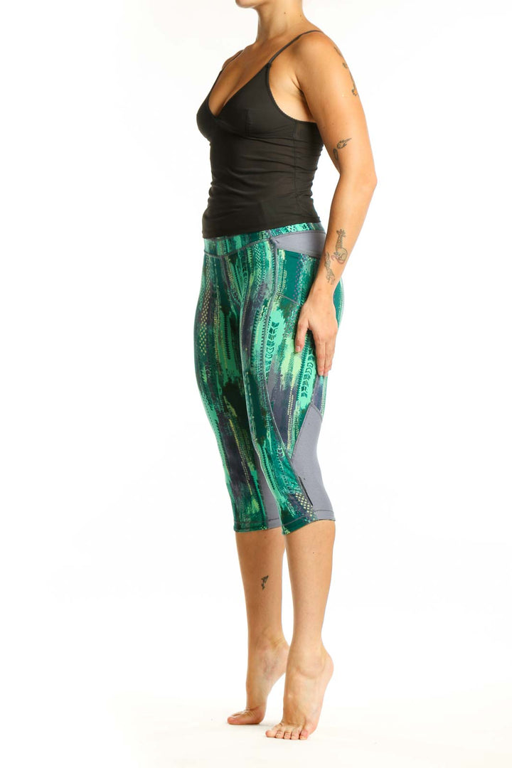 Front view of green geometric print Athleta capri leggings with high-waisted design and four-way stretch fabric