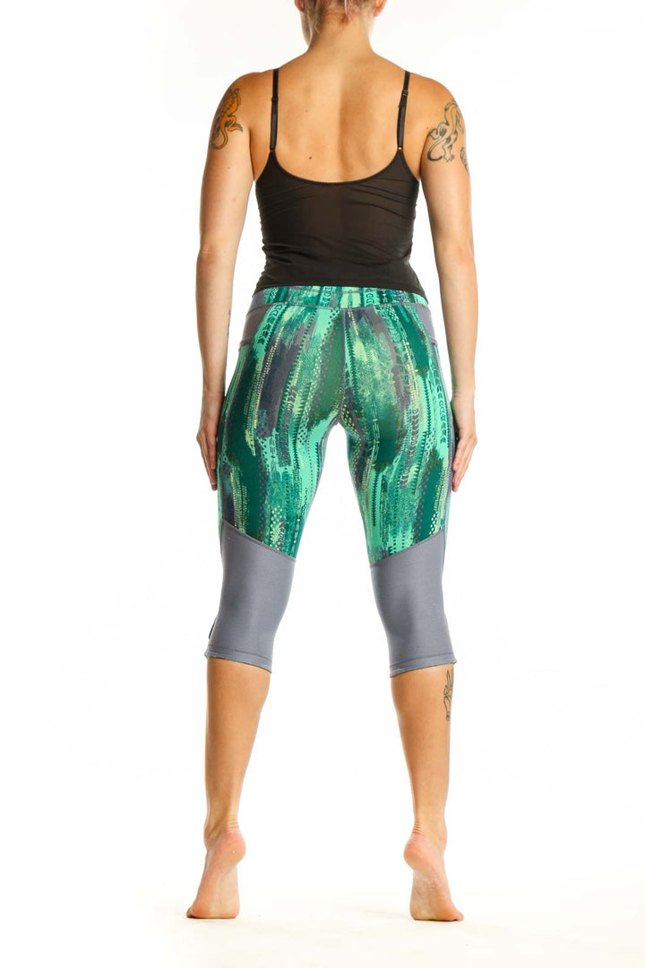 Back view of green geometric print Athleta capri leggings showing flattering fit and calf-length cut