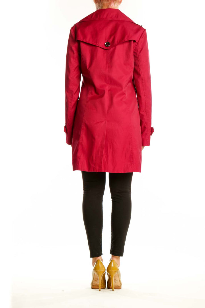 Red double-breasted trench coat by Michael Kors showing back silhouette and A-line cut, back view on model