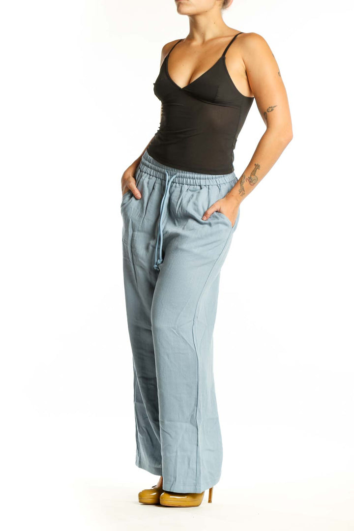 Blue wide leg drawstring pants with elastic waistband and side pockets, front view