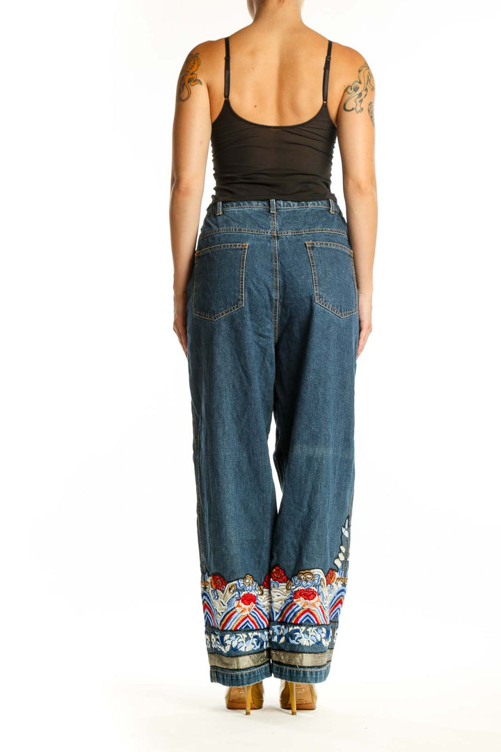 Back view of blue denim jeans showing embroidered floral hem detail and relaxed straight-leg fit
