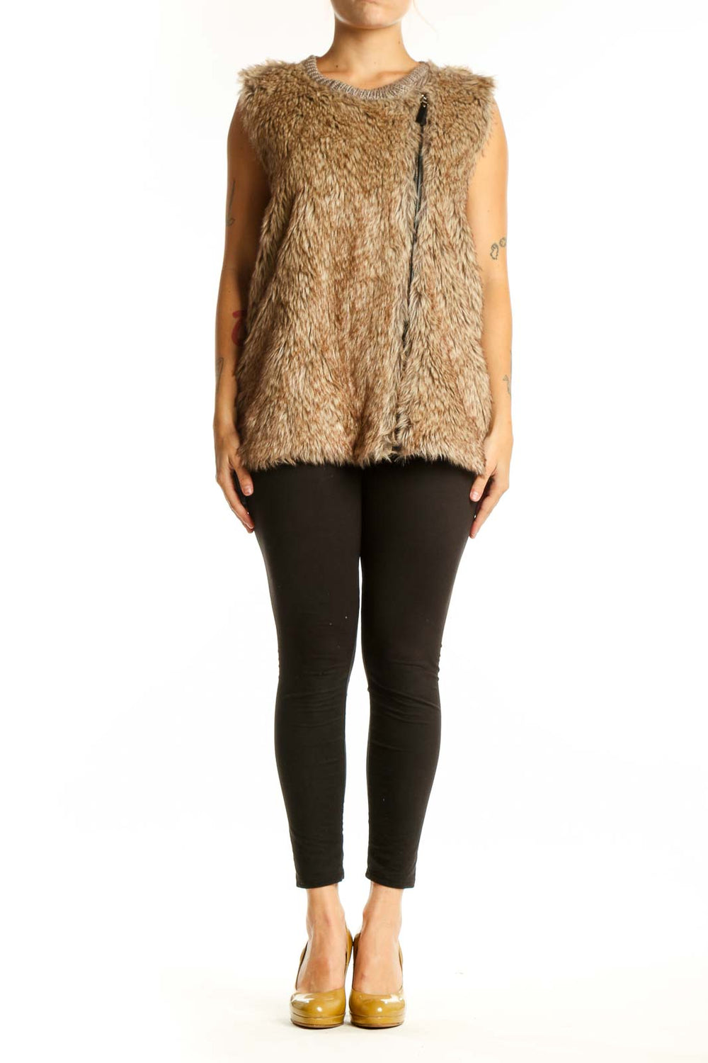Beige fuzzy knit vest with crew neckline and front zipper, worn with black pants