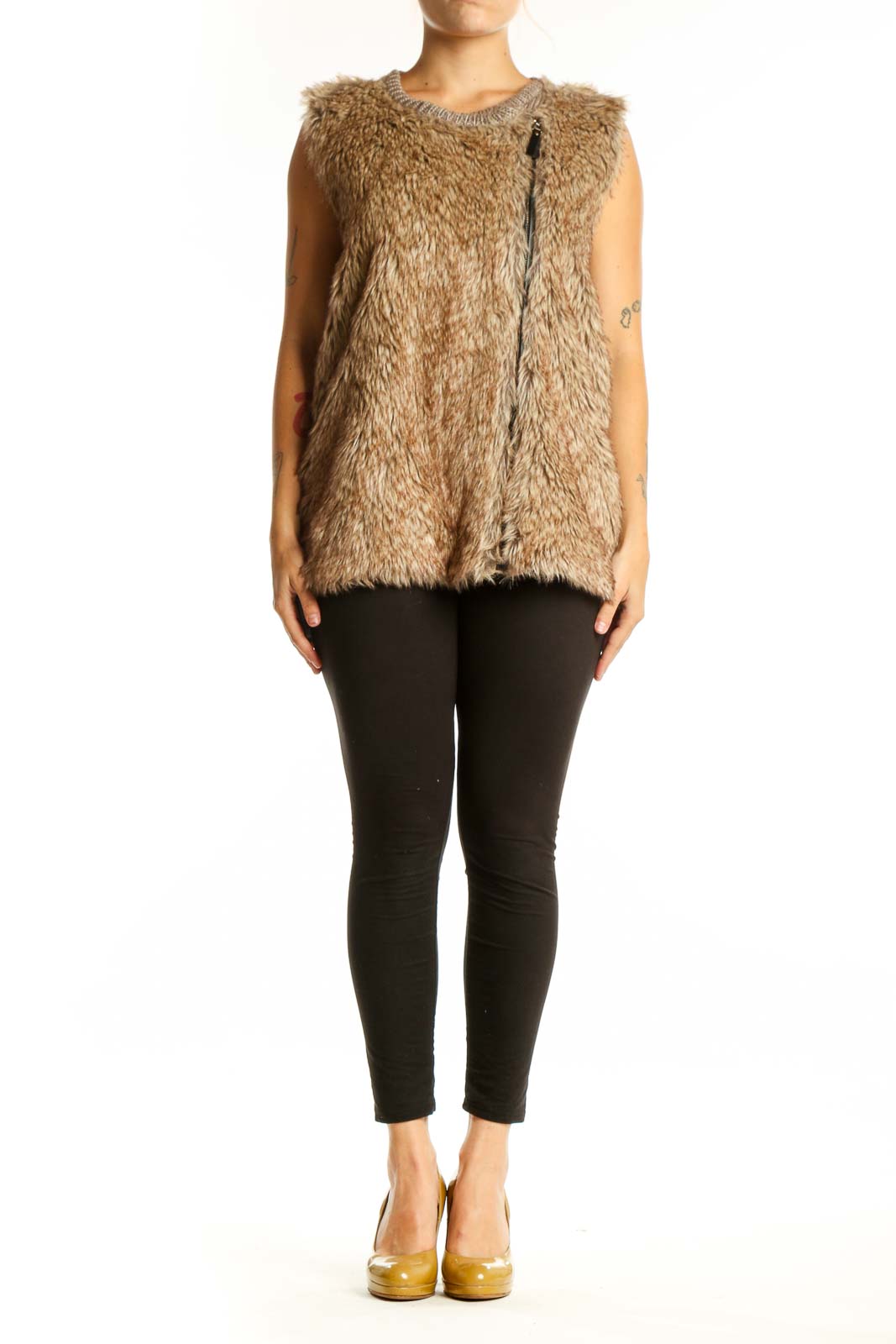 Beige fuzzy knit vest with crew neckline and front zipper, worn with black pants