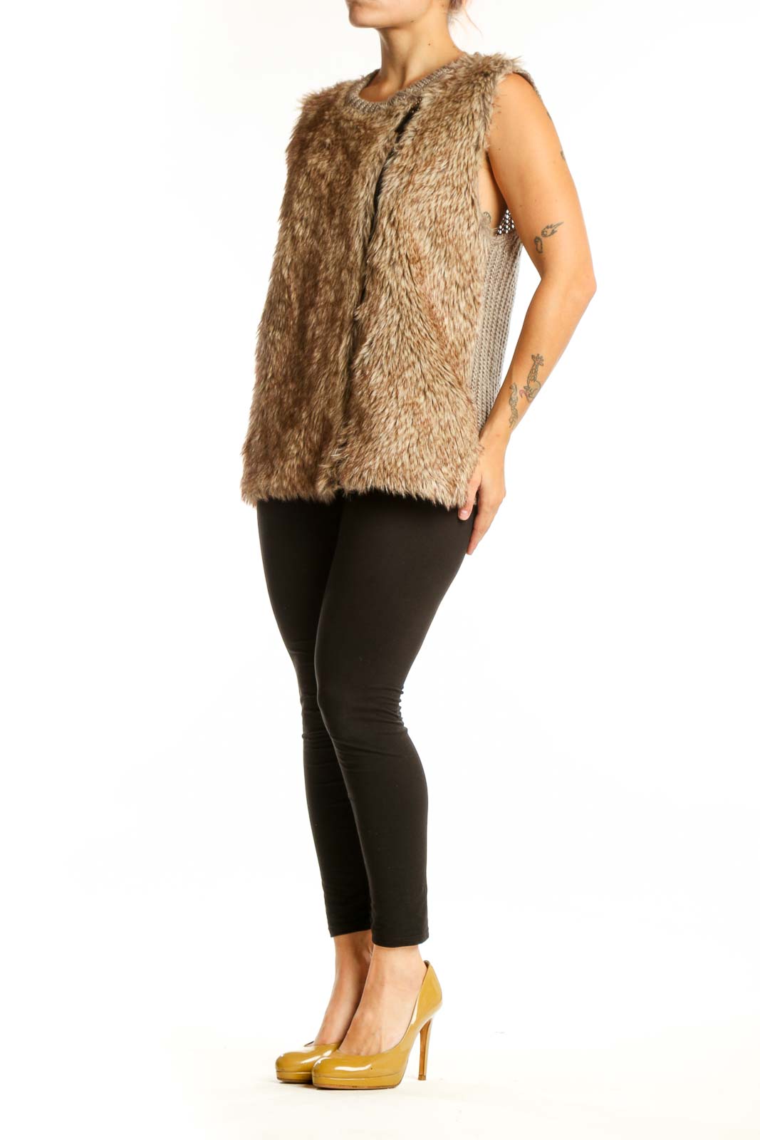 Beige fuzzy knit vest with crew neckline and front zipper, worn with black pants
