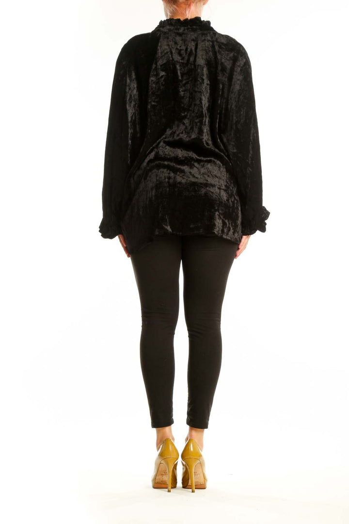 Black crushed velvet button-up blouse with ruffled collar and gathered sleeves, back view