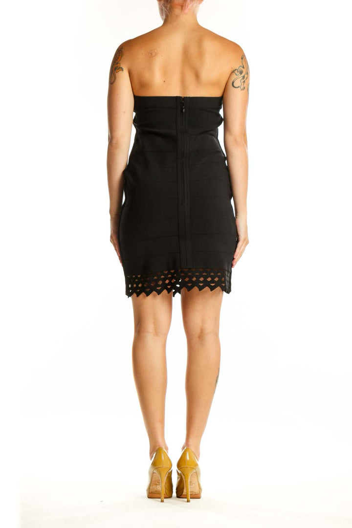 Black strapless cocktail dress with lace trim hem, back view on model