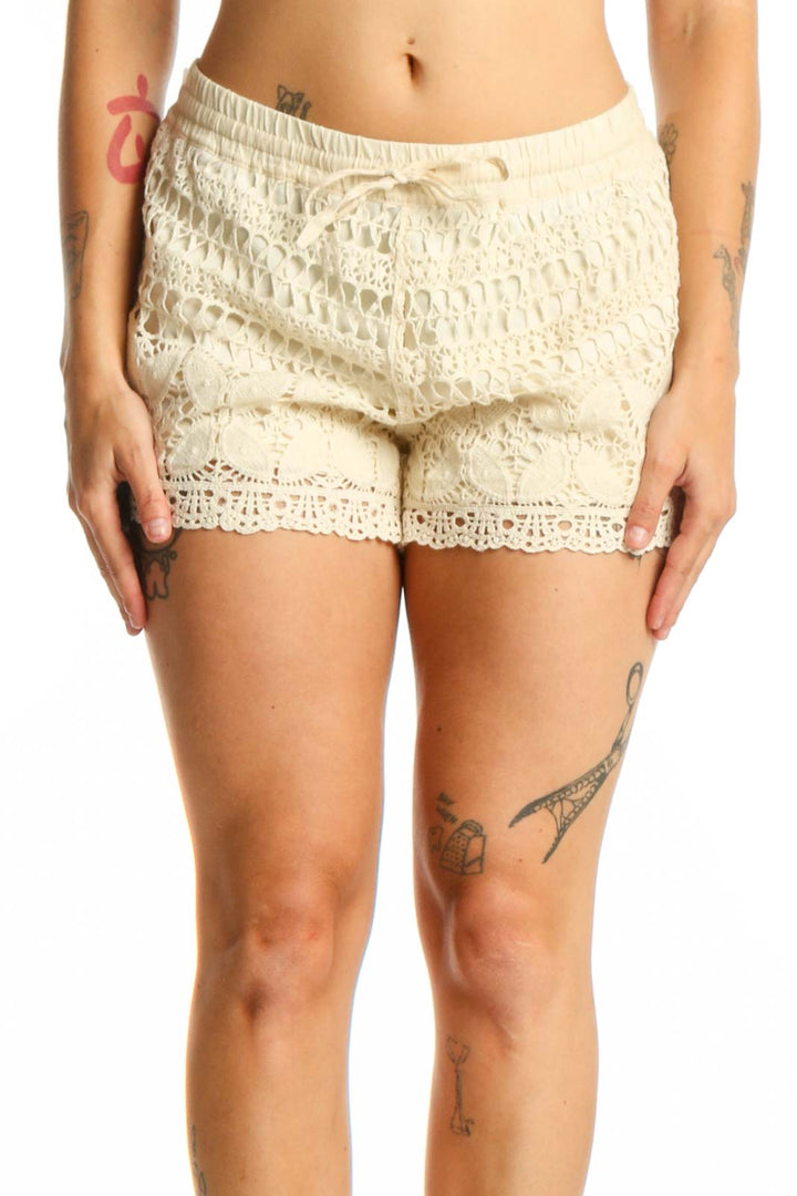 Cream lace shorts with crochet design and drawstring waist, front view on model